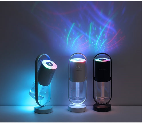 Three LED humidifiers projecting colorful light patterns on a wall in a dark room
